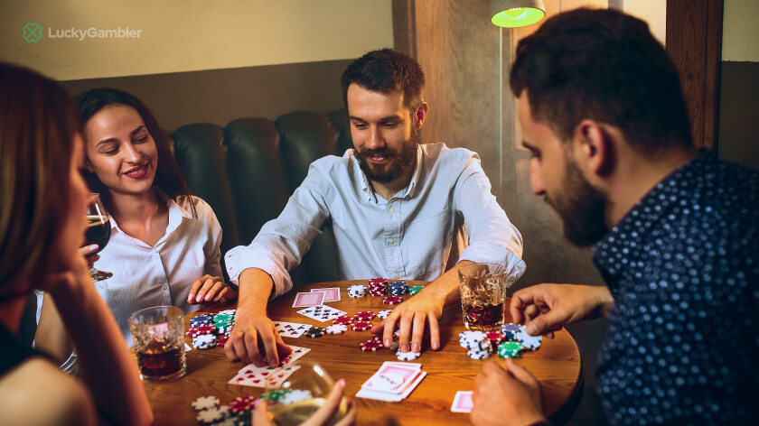 Image of a blackjack table with cards and chips, and a baccarat table with players